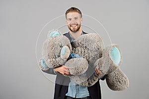 Macho smile with grey teddy bear. Happy man big animal toy. Man smile with big animal toy. Gift and present concept photo