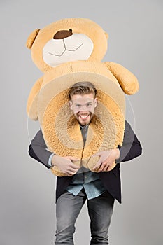 Macho smiling with big animal toy, present photo