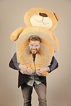 Macho smiling with big animal toy, present photo