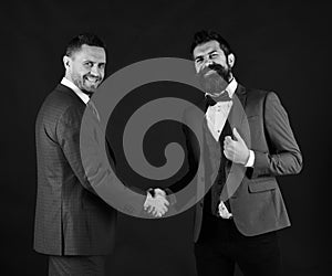Machos in classic suits make business agreement photo