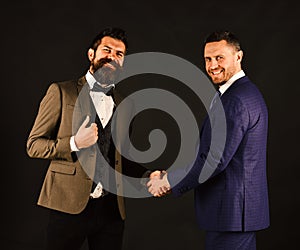 Machos in classic suits make business agreement photo