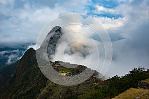 Machu Picchu illuminated by sunlight coming out from the opening clouds. The Inca`s city is the most visited travel destination i