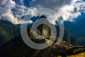 Machu Picchu illuminated by sunlight coming out from the opening clouds. The Inca`s city is the most visited travel destination i
