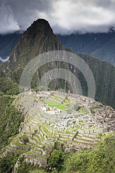 Machu Picchu ruins with cloudy sky in the back