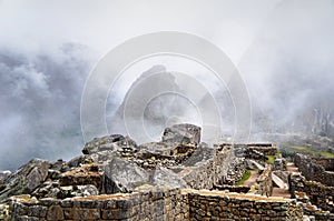 Machu Picchu ruins and mountains in fog