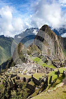 Machu picchu view, vertical orientation, blue sky in the clouds, Peru.