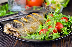 Mackerel baked with lemon. Fish on a plate with vegetables