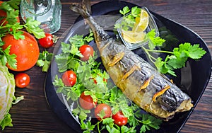 Mackerel baked with lemon. Fish on a plate with vegetables