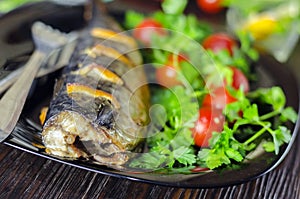 Mackerel baked with lemon. Fish on a plate with vegetables