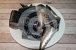 Mackerel cut into pieces, placed on a plate.