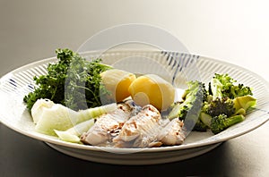 Mackerel fish dish with potatoes, broccoli, onions and parsley. Fatty, oily fish is an excellent and healthy source