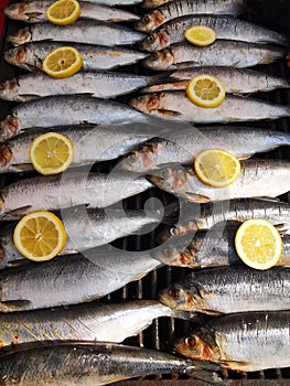 Mackerels on grill with lemon slices