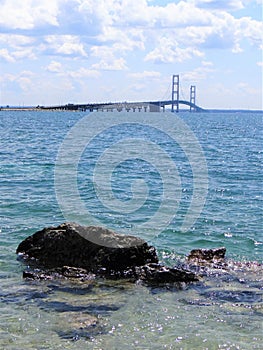 Mackinac Bridge Michigan with Rock near Shoreline in the Foreground beautiful bright Blue and Clear Water Mackinaw City Great