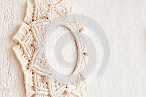 Macrame mandala. Macrame wreathe on a white background close up. Natural cotton thread. Eco home decor.  Copy space