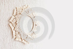 Macrame mandala. Macrame wreathe on a white background close up. Natural cotton thread. Eco home decor.  Copy space