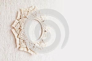 Macrame mandala. Macrame wreathe on a white background close up. Natural cotton thread. Eco home decor.  Copy space