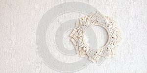 Macrame mandala. Macrame wreathe on a white background. Natural cotton thread. Eco home decor.  Panorama format for site banner,