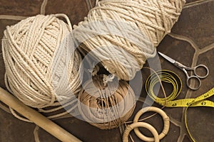 MacramÃ© still life - group of cords and threads with scissors and measure tape including wood elements to handcraft macrame home