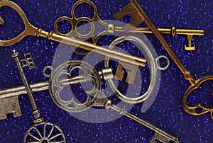 Macro of assorted vintage gold and silver keys on blue background