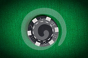 Macro black poker chip on green table