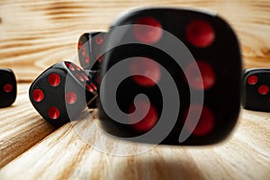 Macro of black tossed dice on wooden background