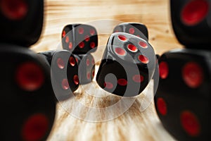 Macro of black tossed dice on wooden background