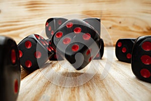 Macro of black tossed dice on wooden background