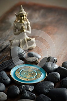 Macro of Blue Incense Holder, Sticks, Buddha and Black Rocks