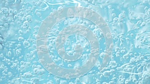 Macro blue transparent cosmetic serum gel, cream, fluid texture with air bubbles