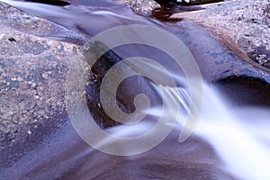 Macro Blurred Motion and Slow Shutter Speed Water Fall Photography over Stone.