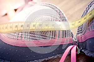Macro Of A Bra With Measuring Tape On Top On A Table - Measure Breast Size Concept