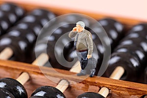 Macro business man doll standing on Chinese abacus making a call