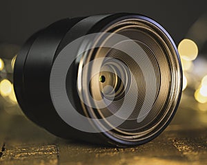 Macro camera lens, lights in background, wooden desk