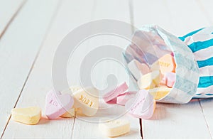 Macro of candy bag spilling heart shaped candies