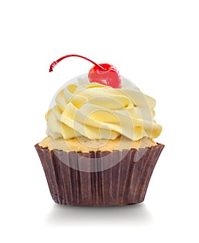 Macro close up of a cupcake with yellow cream and red cherry isolated on white background