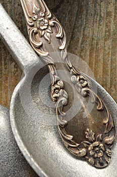 Macro close up detail of tarnished silver spoon handle and pewtr spoon