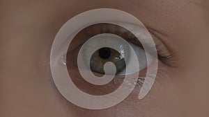 Macro Close-up eye blinking. Young girl is opening and closing herblond hair in school uniform. Boy and girl preschoolers on wind.