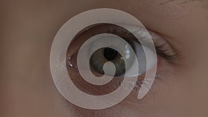 Macro Close-up eye blinking. Young girl is opening and closing herblond hair in school uniform. Boy and girl preschoolers on wind.