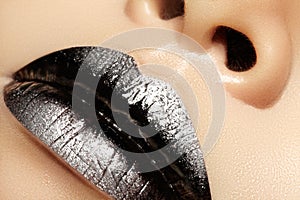 Macro close-up of female mouth. black Gloss Lips with silver glitter Makeup. Halloween Style Make-up. Dark Lipstick