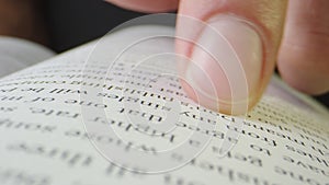 Macro close-up of finger moving through page of music publishing book