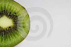 Macro close up of isolated half sliced fresh ripe green kiwifruit with white background and copy space for text