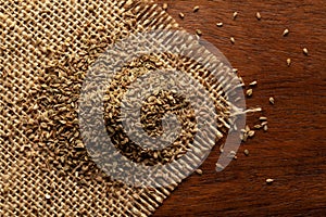 Macro close-up of Organic Ajwain seed Trachyspermum ammi or thymol seeds on the wooden top background and jute mat.