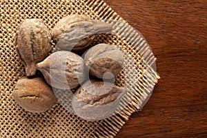 Macro close-up of Organic baheda Terminalia bellirica on wooden top background and jute mat. Pile of Indian Aromatic Spice.