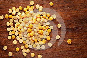 Macro Close-up of Organic Bengal Gram Cicer arietinum or split yellow chana dal cleaned on wooden top background