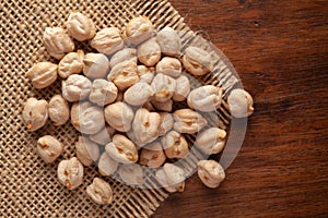 Macro Close-up of Organic Chole Chana or Kabuli Chana Cicer arietinum or whole white Bengal Gram Dal on Jute mat and wooden