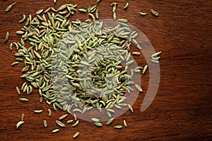 Macro close-up of Organic green fennel seed Foeniculum vulgare  small size on wooden top background.