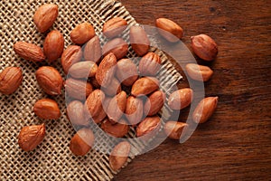 Macro Close-up of Organic Red-brown peanuts Arachis hypogaea  on Jute mat and wooden