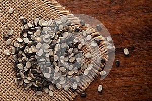 Macro Close-up of Organic split black urad dal Vigna Mungo with the shell on jute mat and wooden
