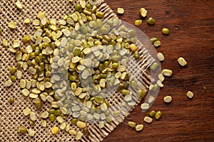 Macro Close-up of Organic split and unpolished Green Moong Dal Vigna radiata on Jute mat and wooden