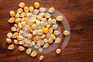 Macro Close up organic yellow corn seed or maize Zea mays cleaned on wooden top background